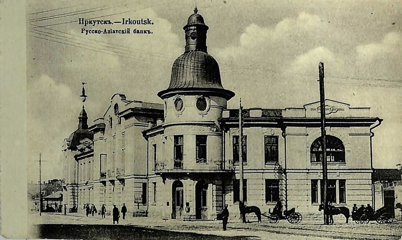 Здание Русско-Азиатского банка находится в центре Иркутска. Фасад, выходящий на Амурскую улицу, довольно прост, другой, обращенный на Большую, не лишен помпезности. Центральный ризалит украшен балконами с металлическими решетками и высокими полуколоннами, которые на уровне аттика завершаются аллегорическими скульптурами, символизирующими самодержавие. В барельефе, расположенном между скульптурами,— портретное изображение императрицы Екатерины II. В архитектуре города это, пожалуй, наиболее удачная постройка в стиле модерн. 90.jpg