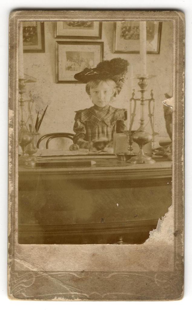 Девочка Гладышева Ольга Ивановна за письменным столом в кабинете. 1904