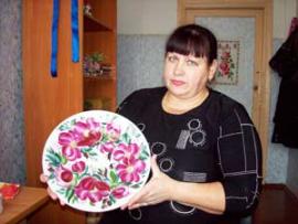 Людмила Шишкина показывает тарелку с традиционной хайтинской росписью