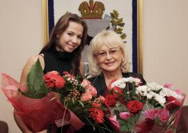 Дарья Дмитриева со своим тренером Ольгой Буяновой на фоне герба Иркутской области